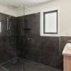 Black tiled bathroom with timber look vanity