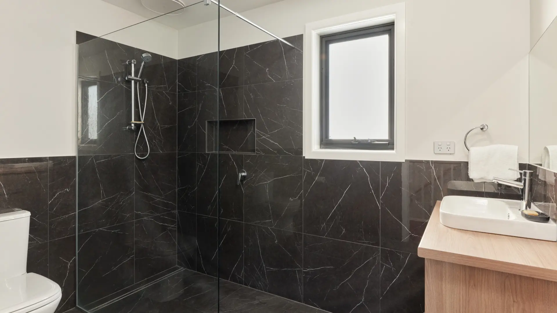 Black tiled bathroom with timber look vanity