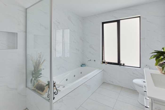 Clean white marble tile bathroom with spa bath