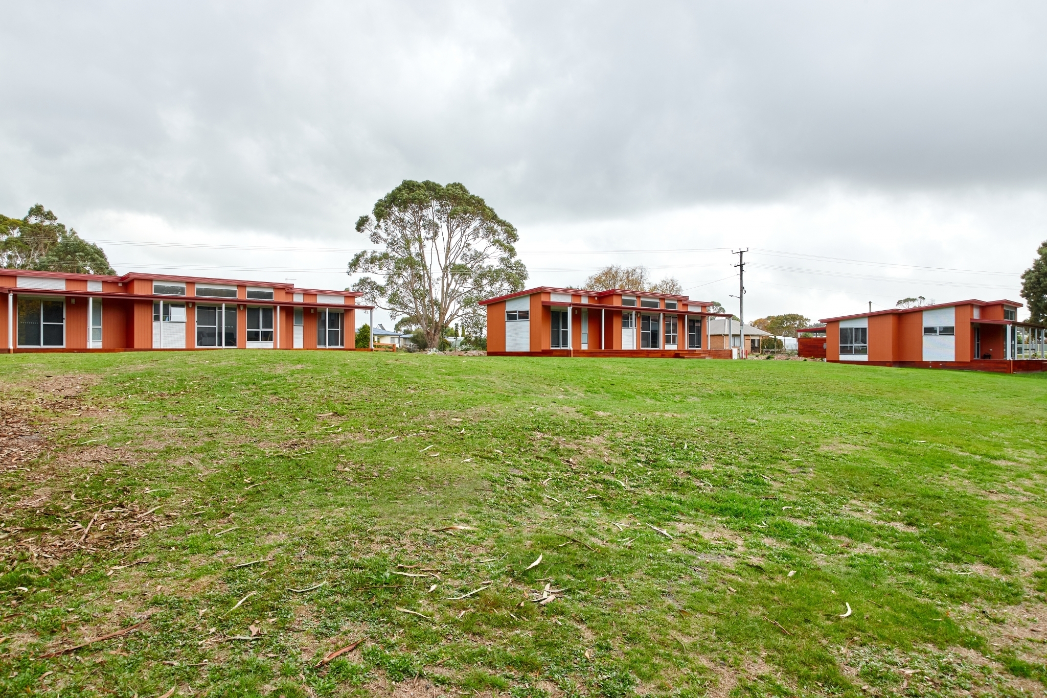 Exterior view of Tasbuilt Homes’ Accommodation Units in Smithton, Tasmania, showing three modern self-contained units with timber and Zincalume finishes, decks, and large windows for natural light and views.