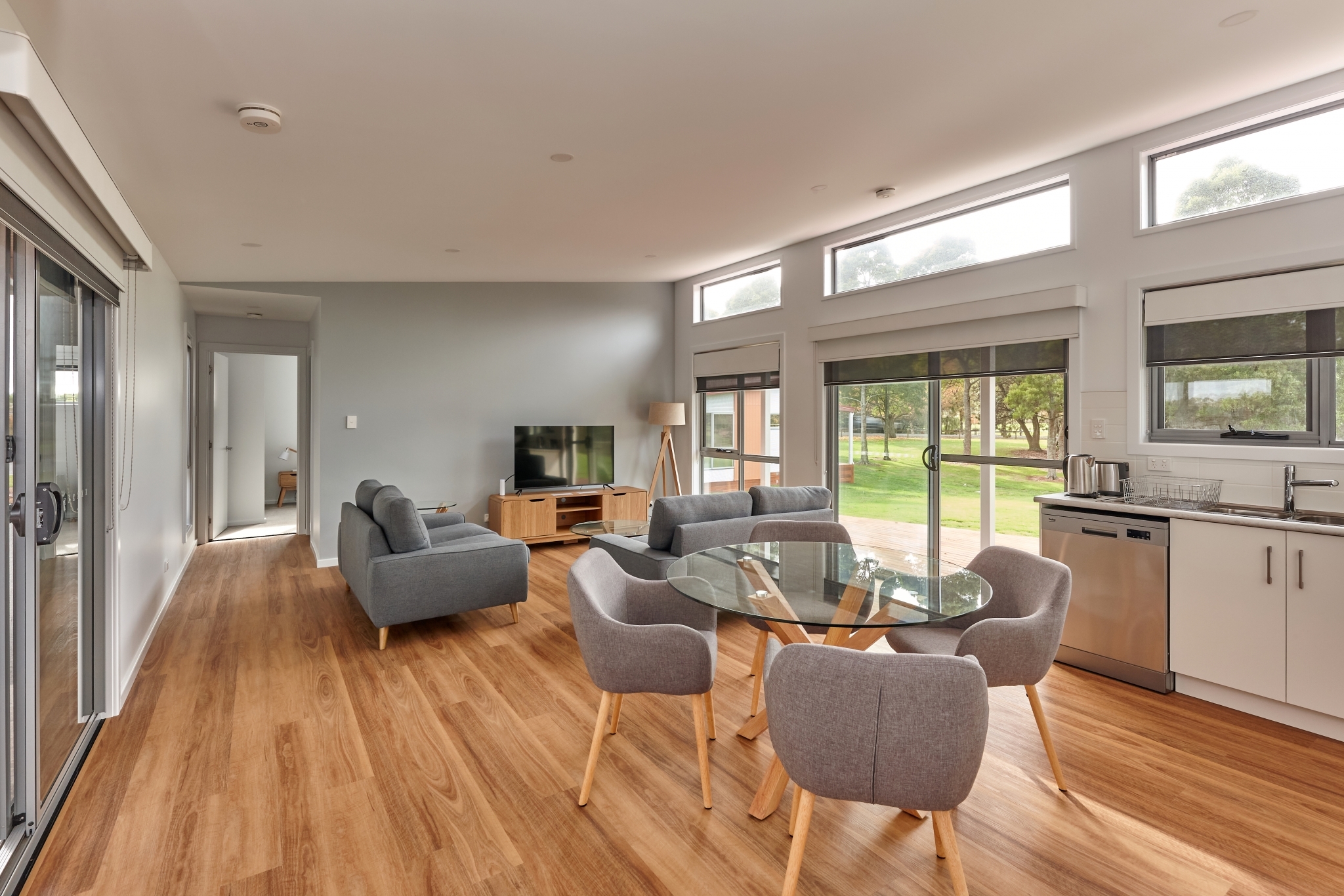 Interior view of Tasbuilt Commercial’s modern accommodation units in Smithton, Tasmania, showcasing a spacious open-plan living area with contemporary finishes, large windows, and warm timber accents.