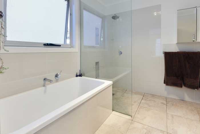 Cream Bathroom with Walk-In Shower and Tiled Bathtub