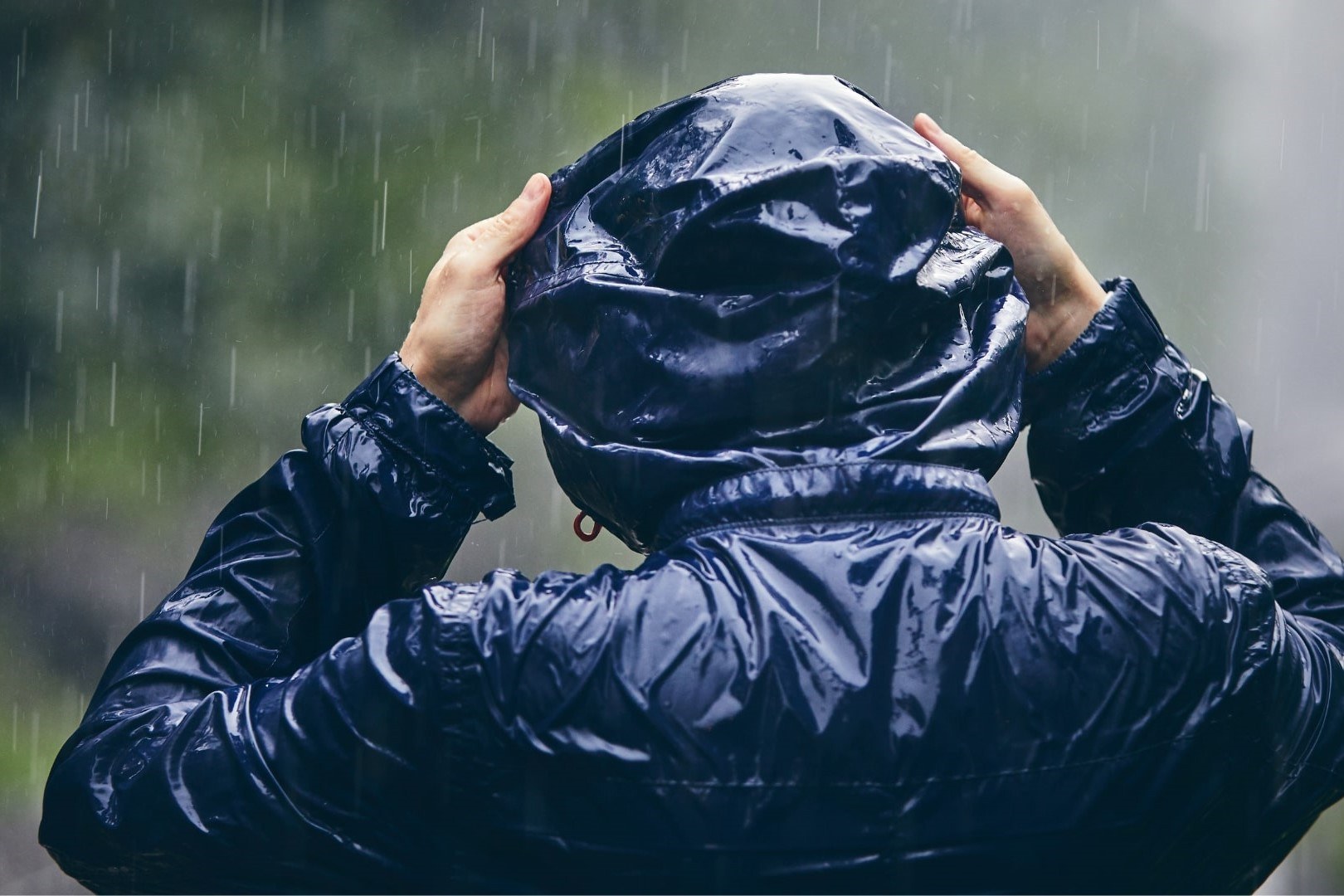 A waterproof blue rain jacket with hood, representing the importance of weather-ready materials.