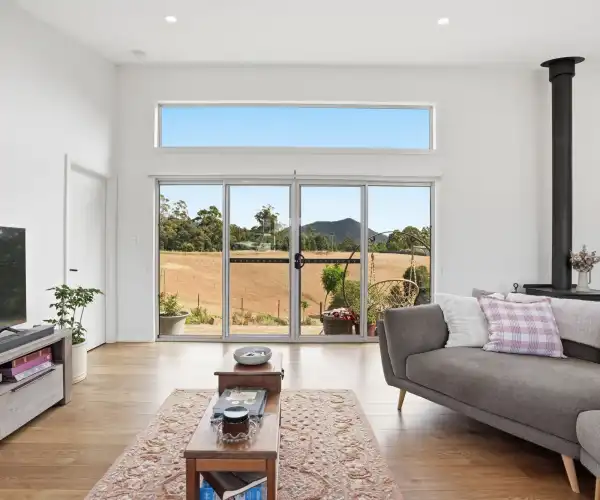 Large sliding glass doors in the open-plan living room provide an unobstructed view of the surrounding Tasmanian countryside.