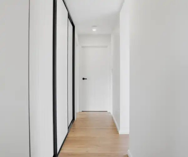 A view of the modern internal hallway that seamlessly connects the original modular build with the newer bedroom extension.
