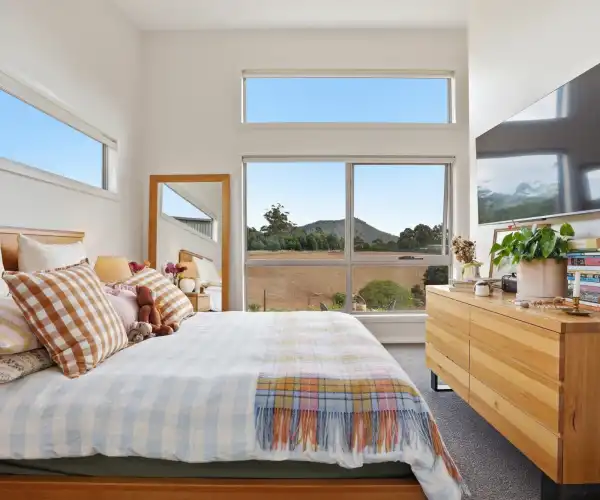 The internal bedroom features a large window that frames the view of the property, creating a bright and restful space.