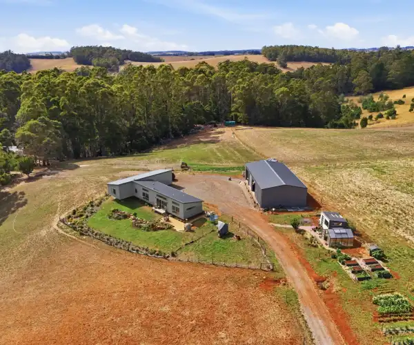 This close-up aerial shot highlights the front of the residence and its positioning within the surrounding rural environment.